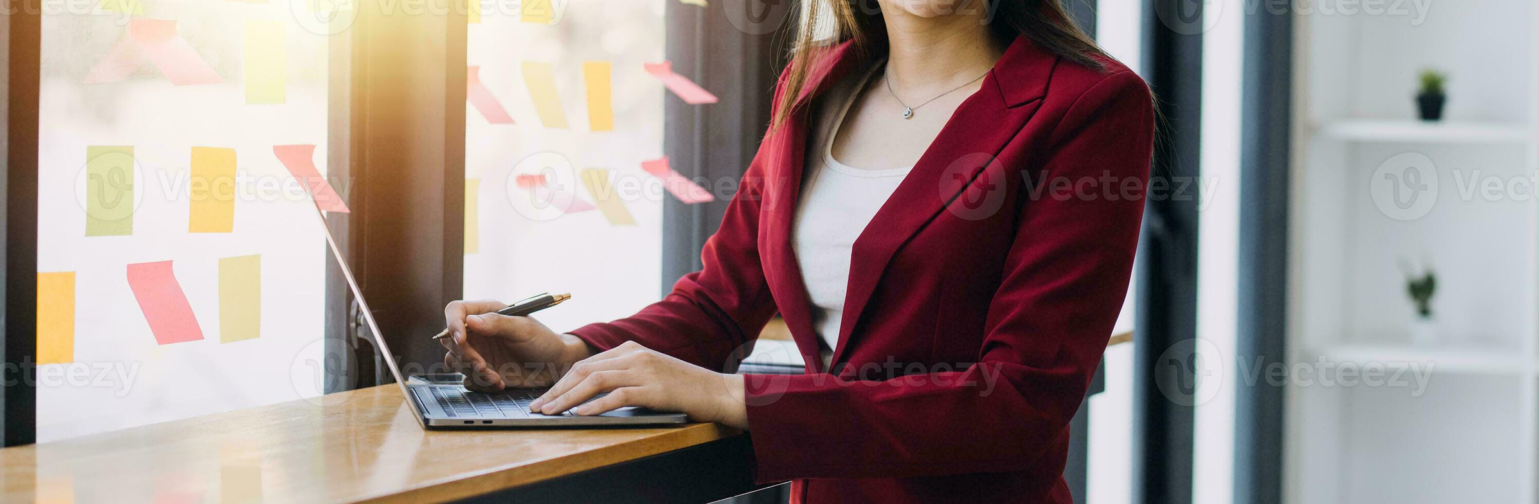 Asian Business woman using calculator and laptop for doing math finance on an office desk, tax, report, accounting, statistics, and analytical research concept photo
