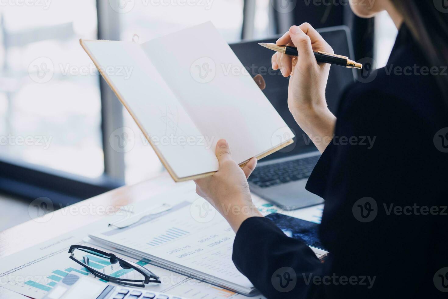 Asian Business woman using calculator and laptop for doing math finance on an office desk, tax, report, accounting, statistics, and analytical research concept photo