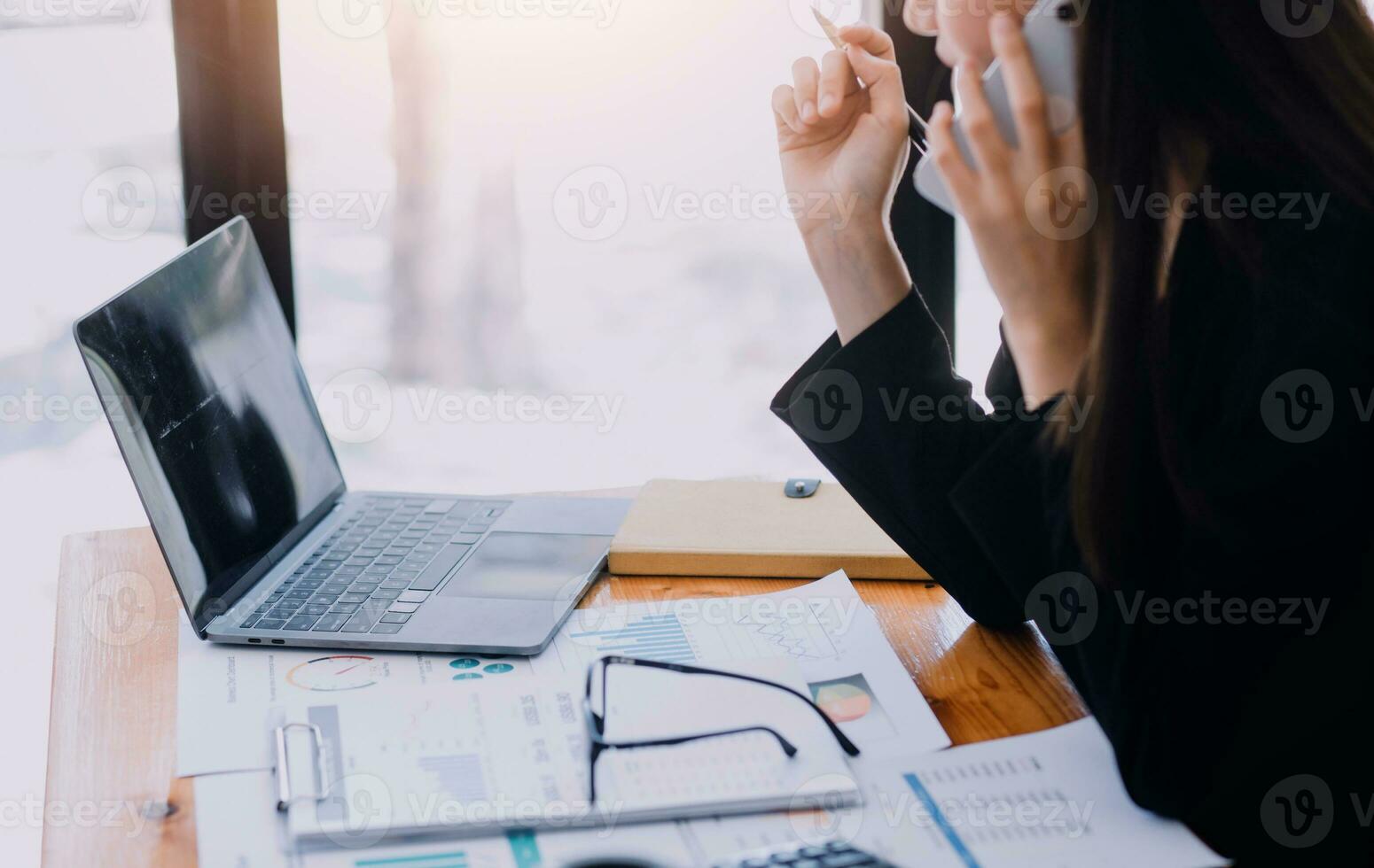 Asian Business woman using calculator and laptop for doing math finance on an office desk, tax, report, accounting, statistics, and analytical research concept photo