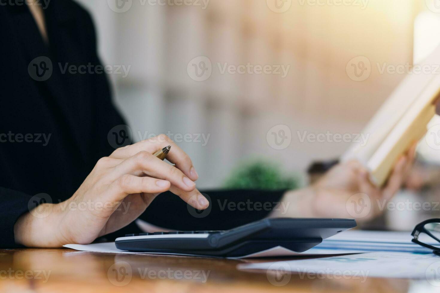 Asian Business woman using calculator and laptop for doing math finance on an office desk, tax, report, accounting, statistics, and analytical research concept photo