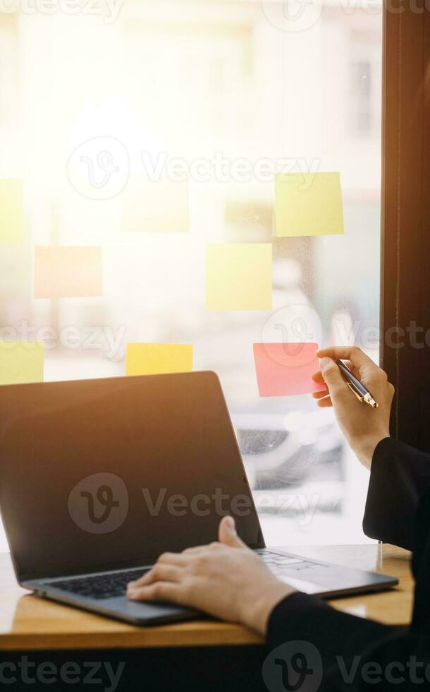 Asian Business woman using calculator and laptop for doing math finance on an office desk, tax, report, accounting, statistics, and analytical research concept photo