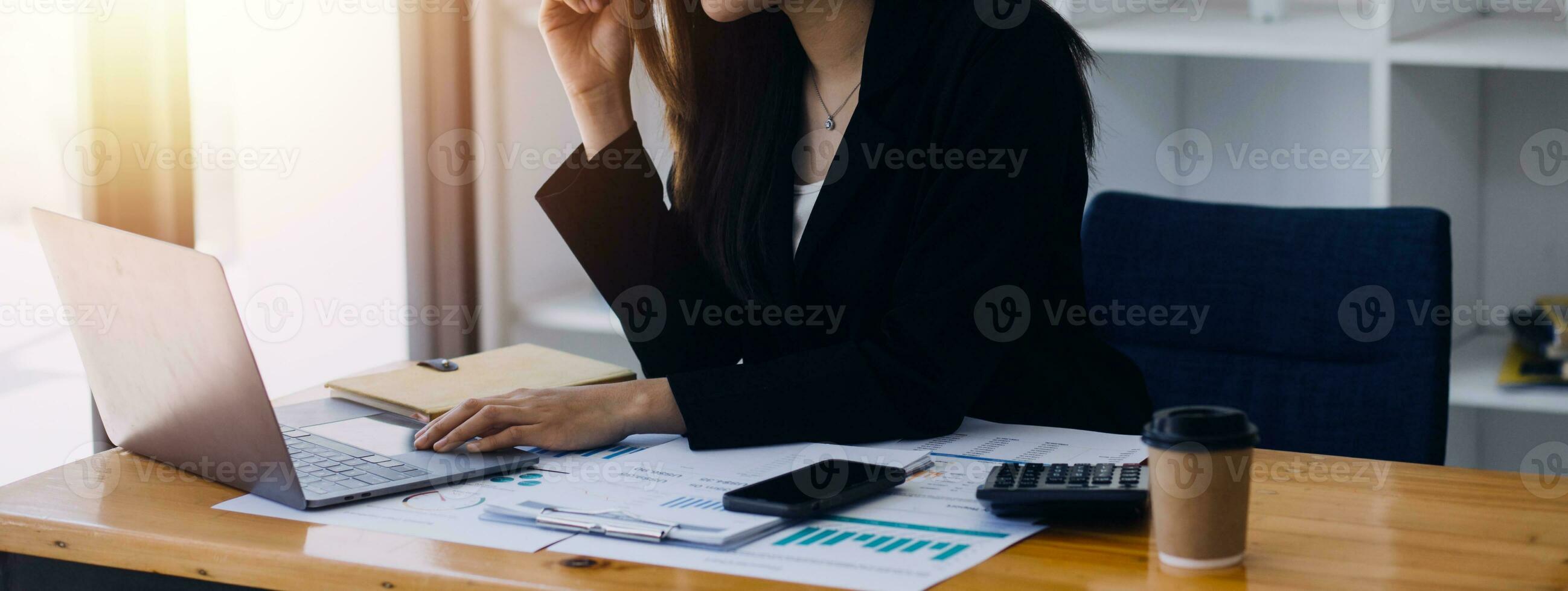Asian Business woman using calculator and laptop for doing math finance on an office desk, tax, report, accounting, statistics, and analytical research concept photo