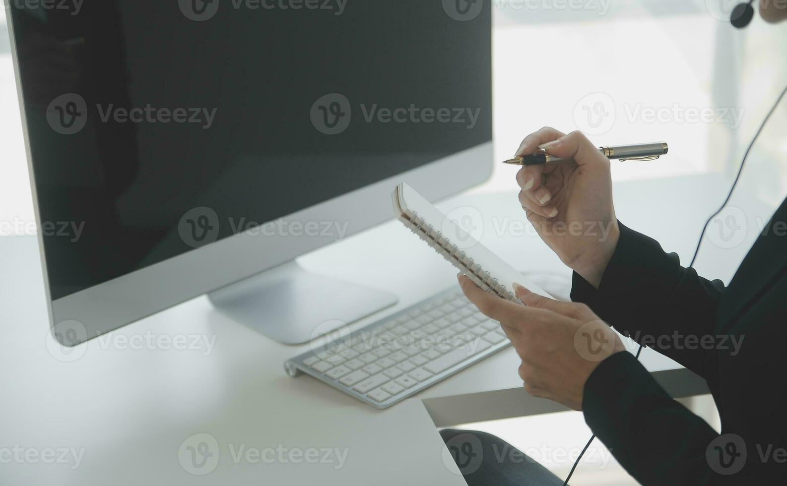 Beautiful female call center operator working on computer in office photo