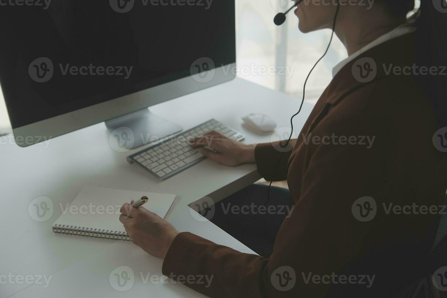 Beautiful female call center operator working on computer in office photo