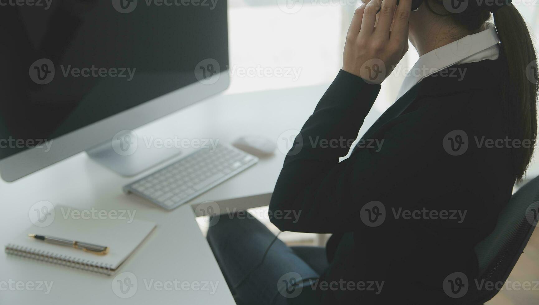 Beautiful female call center operator working on computer in office photo
