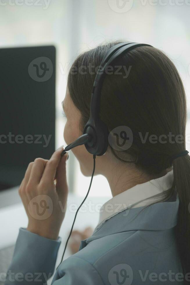 Beautiful female call center operator working on computer in office photo