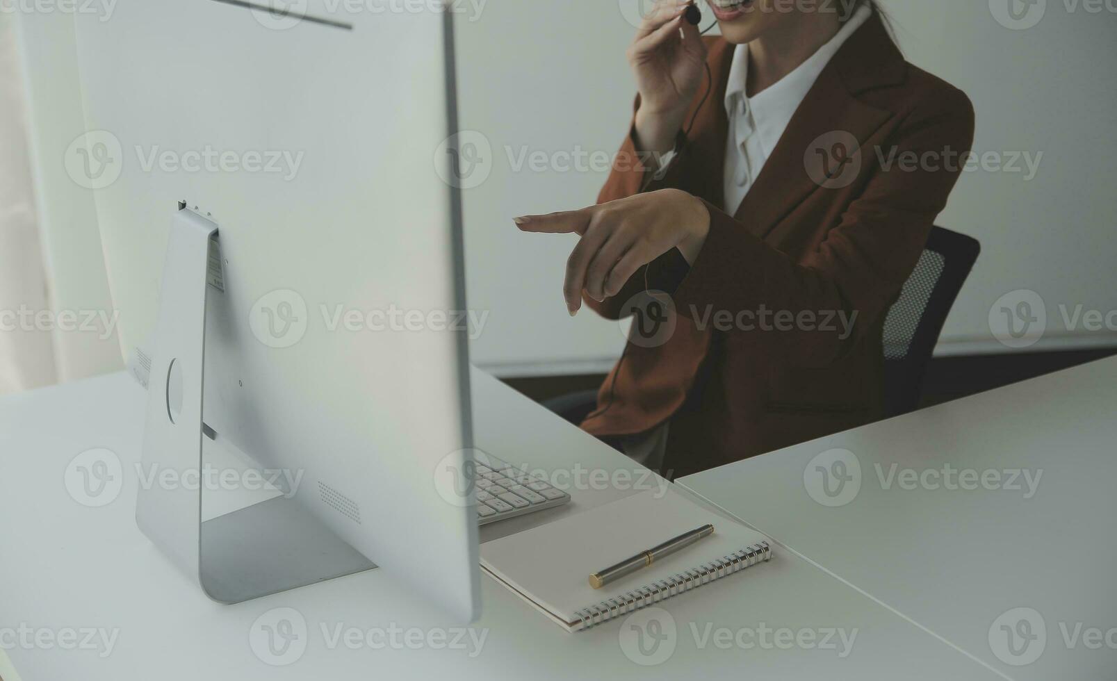Beautiful female call center operator working on computer in office photo