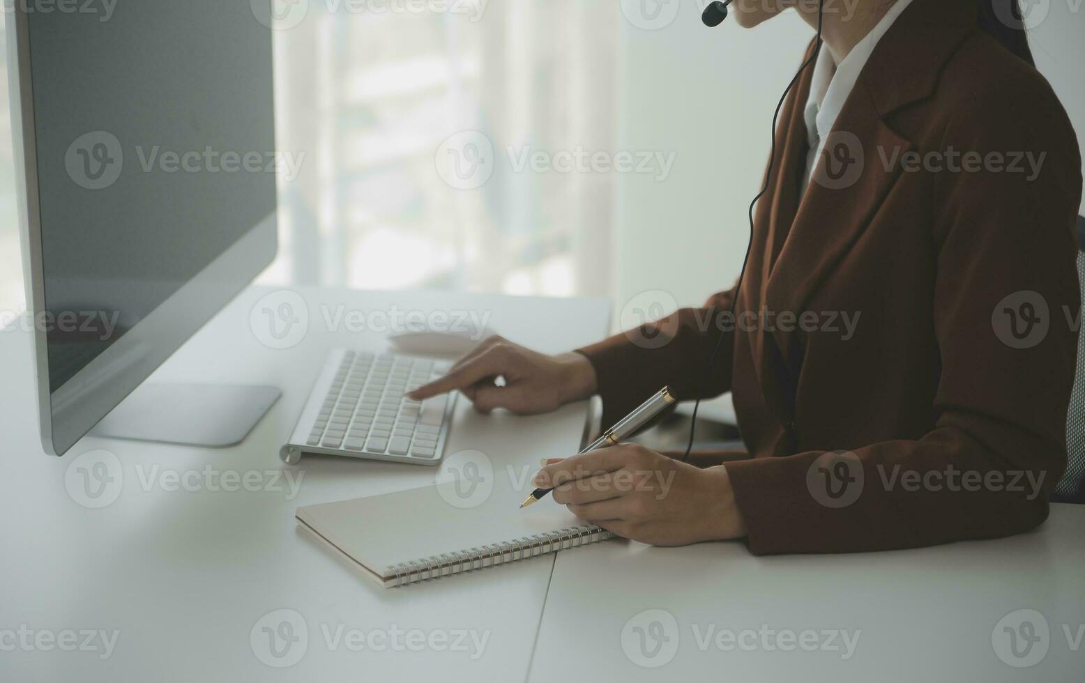 Beautiful female call center operator working on computer in office photo