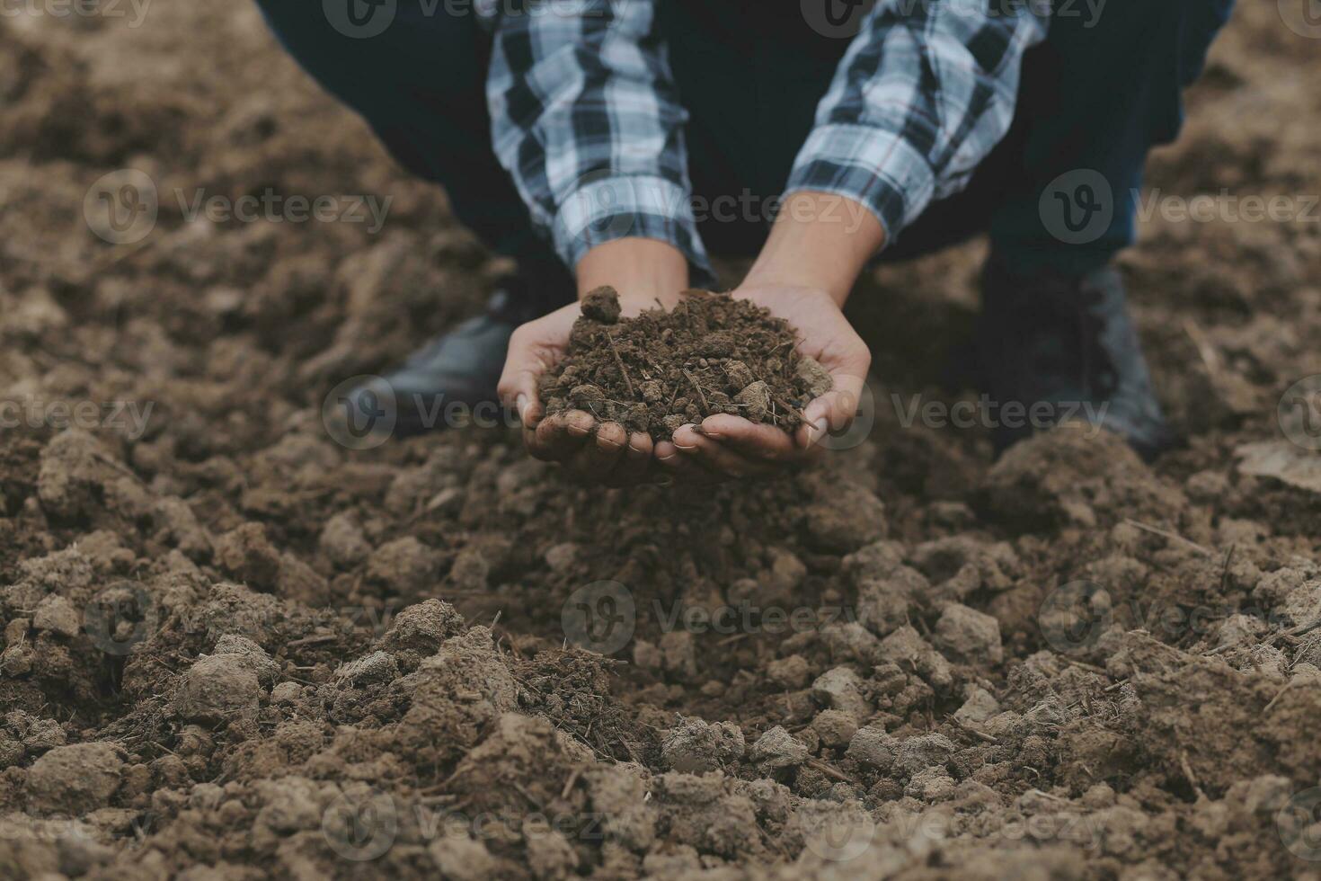 Male hands touching soil on the field. A farmer checks quality of soil before sowing. Agriculture, gardening or ecology concept. photo