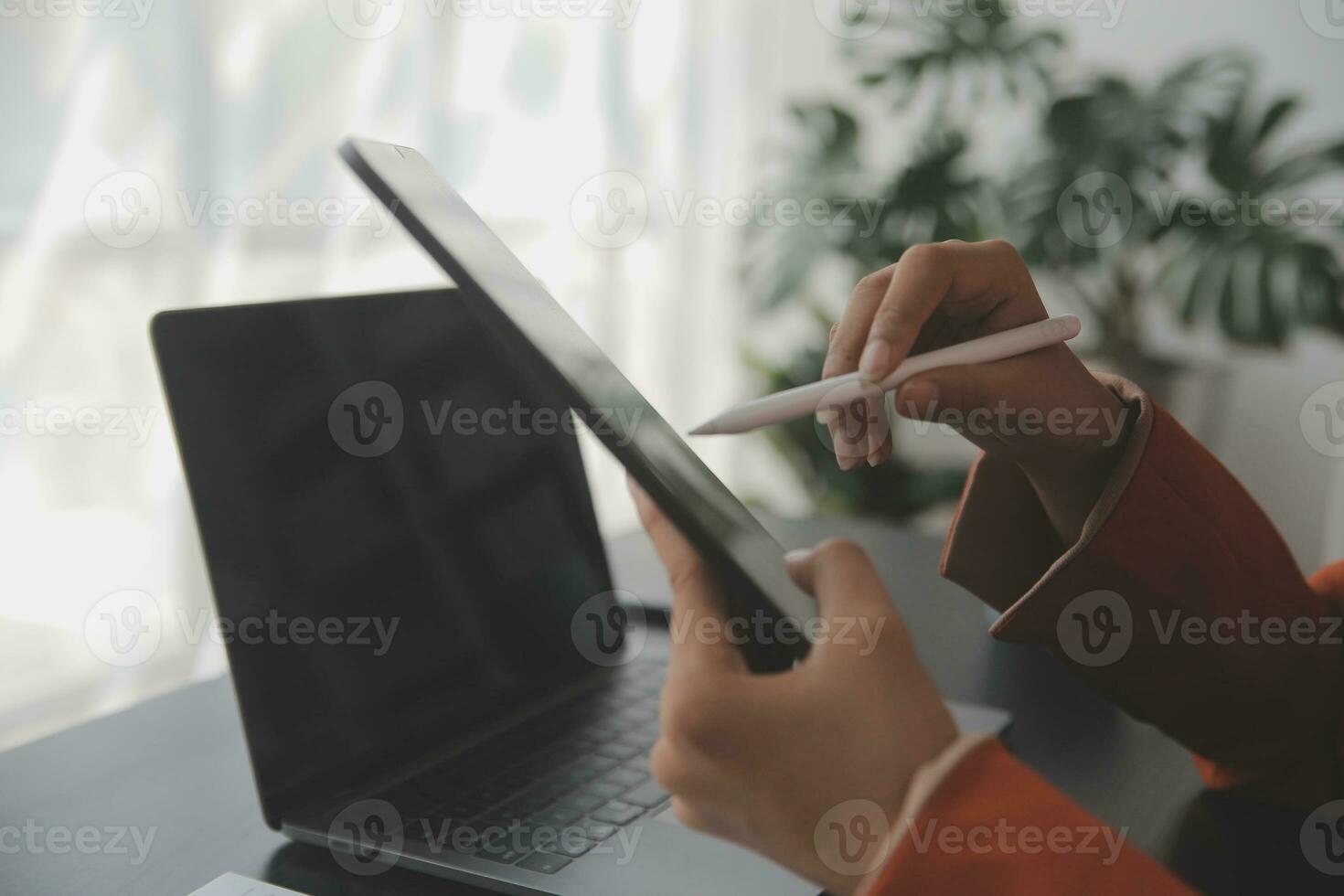 Portrait of Young Asian woman hand freelancer is working her job on computer tablet in modern office. Doing accounting analysis report real estate investment data, Financial and tax systems concept. photo