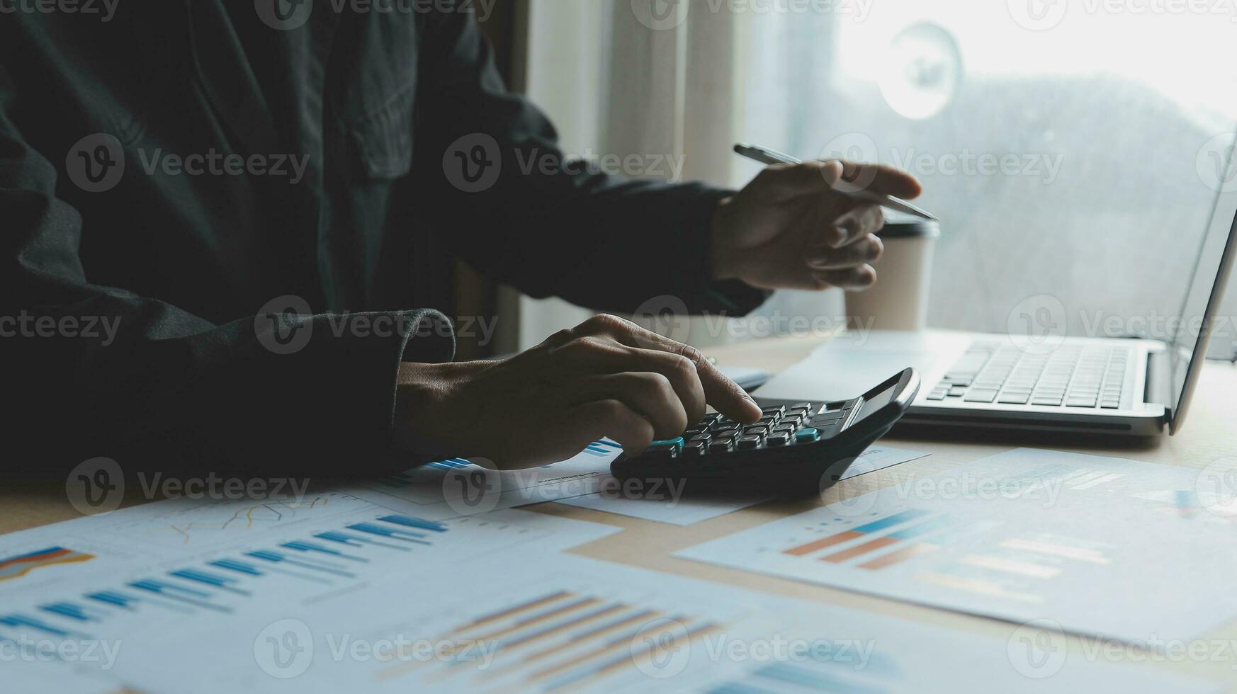 Close up businessman hand using calculator and working with laptop calculate about finance accounting at coffeeshop outdor.finance accounting concept photo