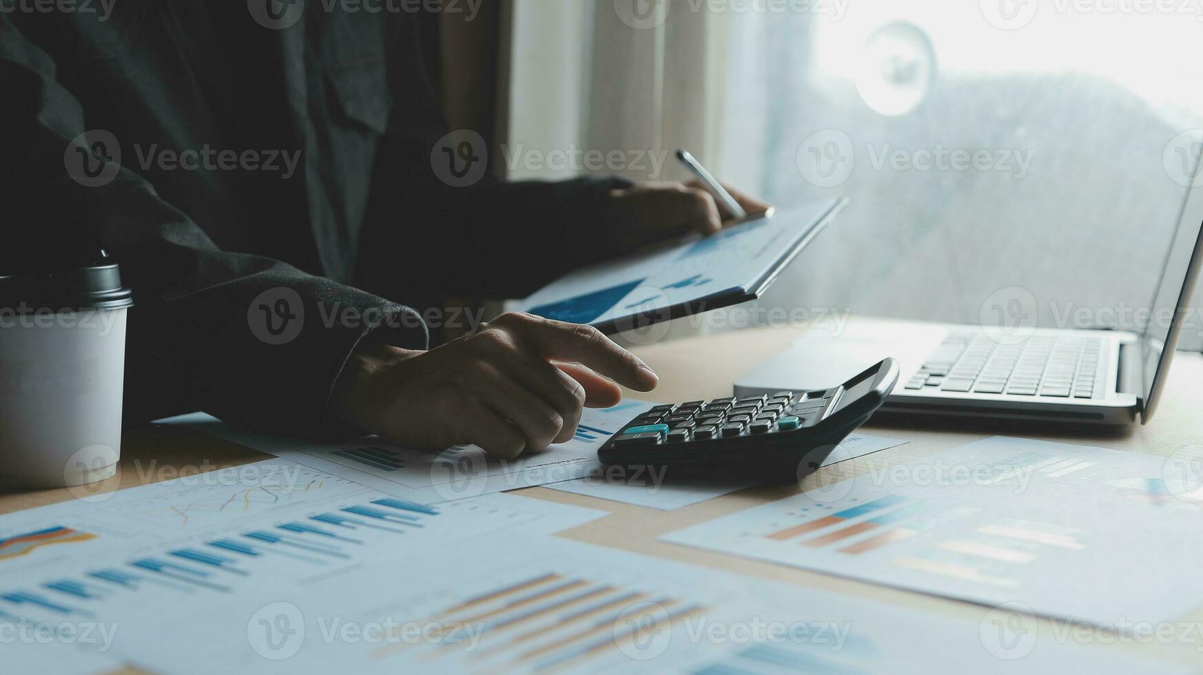 Close up businessman hand using calculator and working with laptop calculate about finance accounting at coffeeshop outdor.finance accounting concept photo