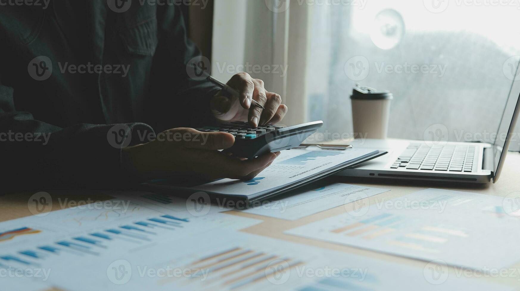 Close up businessman hand using calculator and working with laptop calculate about finance accounting at coffeeshop outdor.finance accounting concept photo