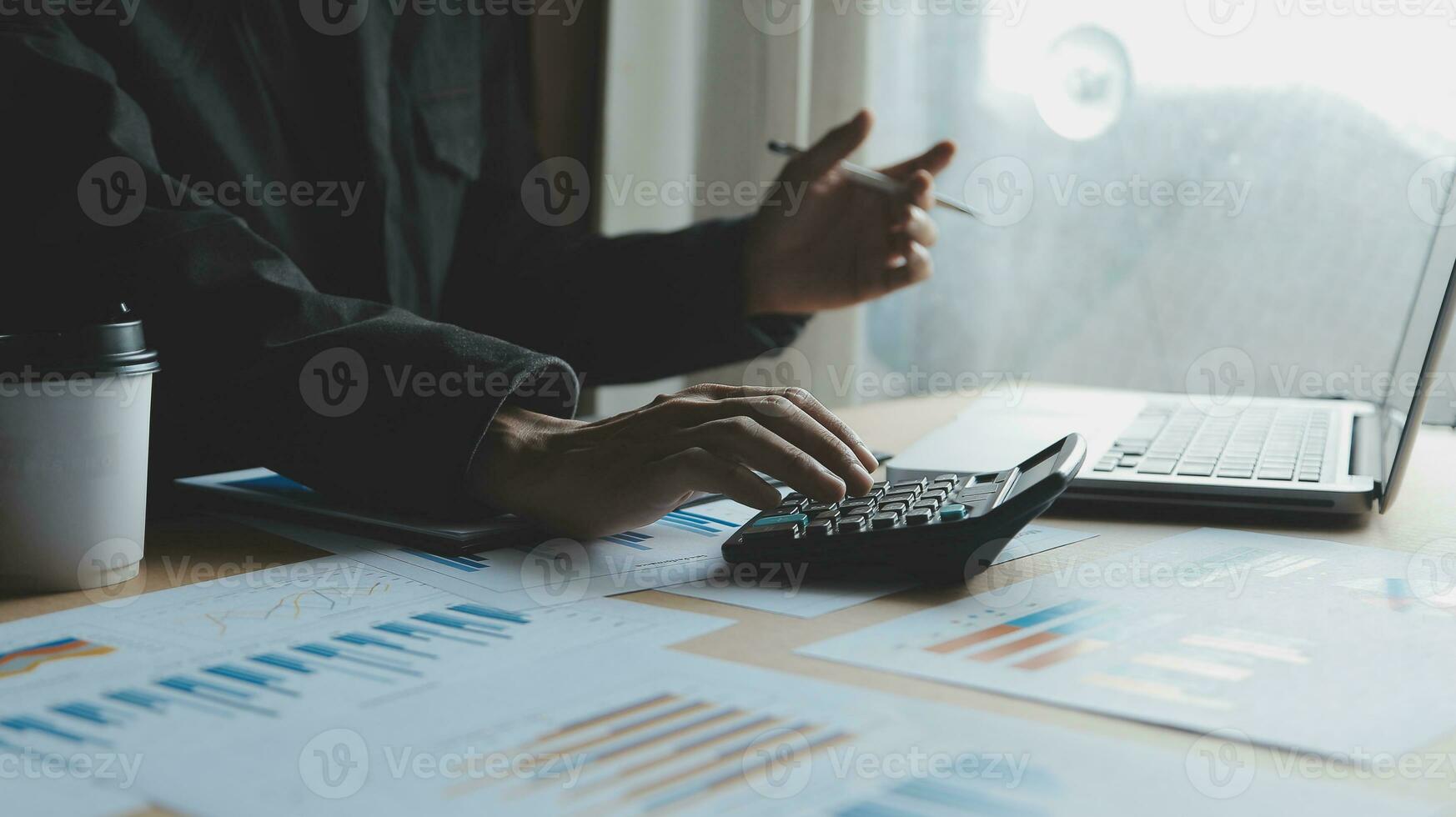 Close up businessman hand using calculator and working with laptop calculate about finance accounting at coffeeshop outdor.finance accounting concept photo