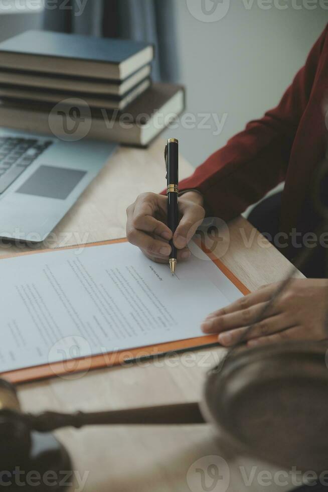 Justice and law concept.Male judge in a courtroom with the gavel, working with, computer and docking keyboard, eyeglasses, on table in morning light photo