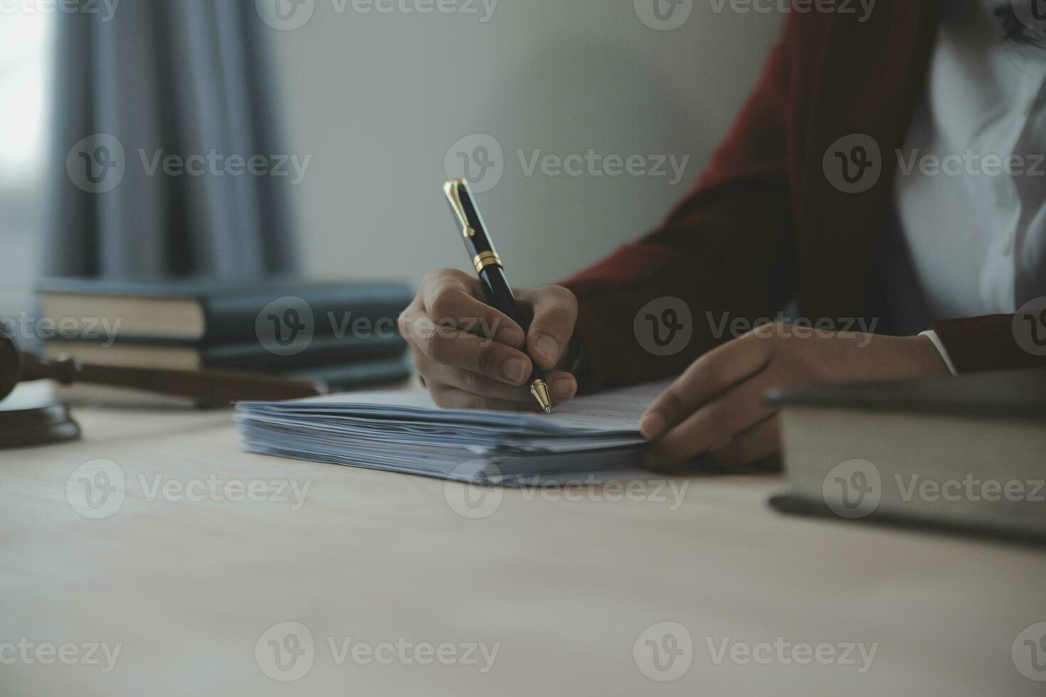 Justice and law concept.Male judge in a courtroom with the gavel, working with, computer and docking keyboard, eyeglasses, on table in morning light photo