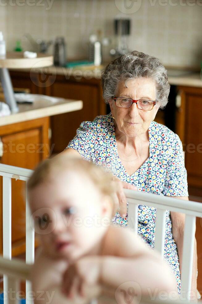 A senior woman and a granddaughter of one year old in its bed photo