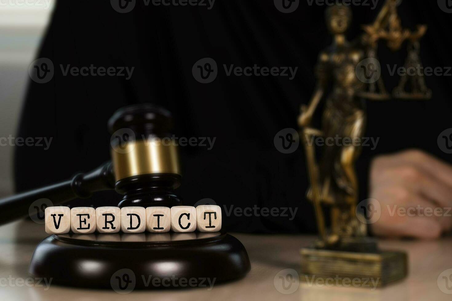 Word VERDICT composed of wooden dices. Wooden gavel and statue of Themis in the background. photo