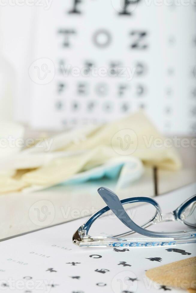 Eyeglasses for children on a eye chart close to eye pads. photo
