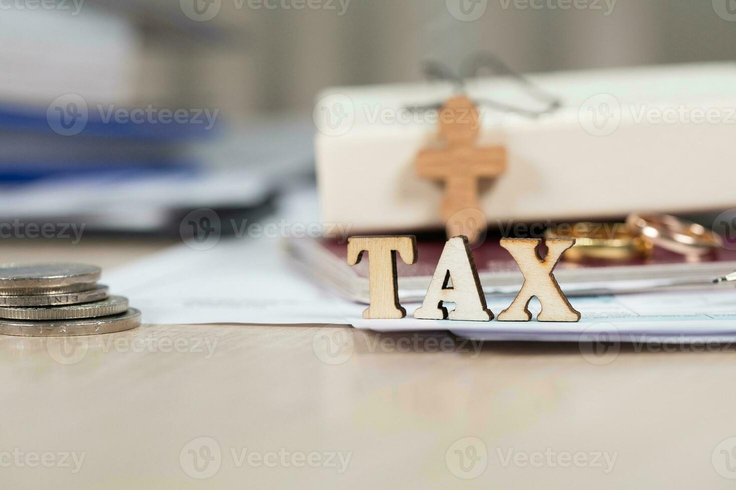 Word TAX composed of wooden letters in front of marriage golden rings. photo