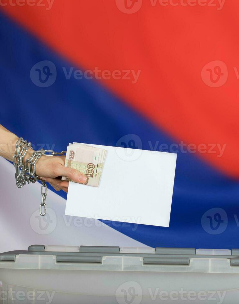 Female hand casts ballot paper in the ballot box. photo