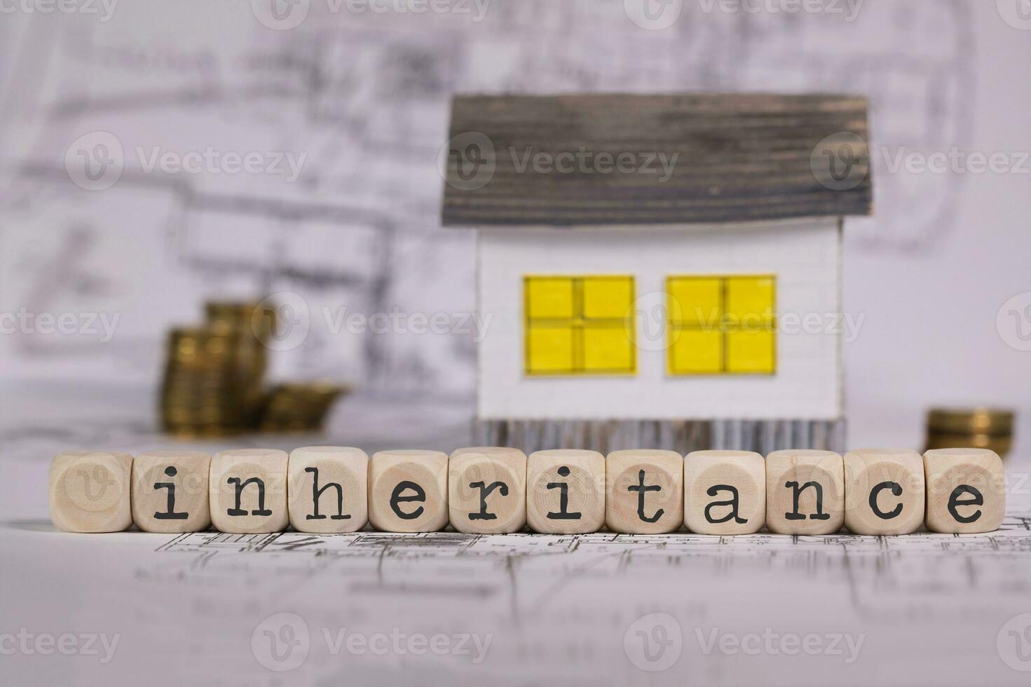 Word INHERITANCE composed of wooden letter. Small paper house in the background. photo