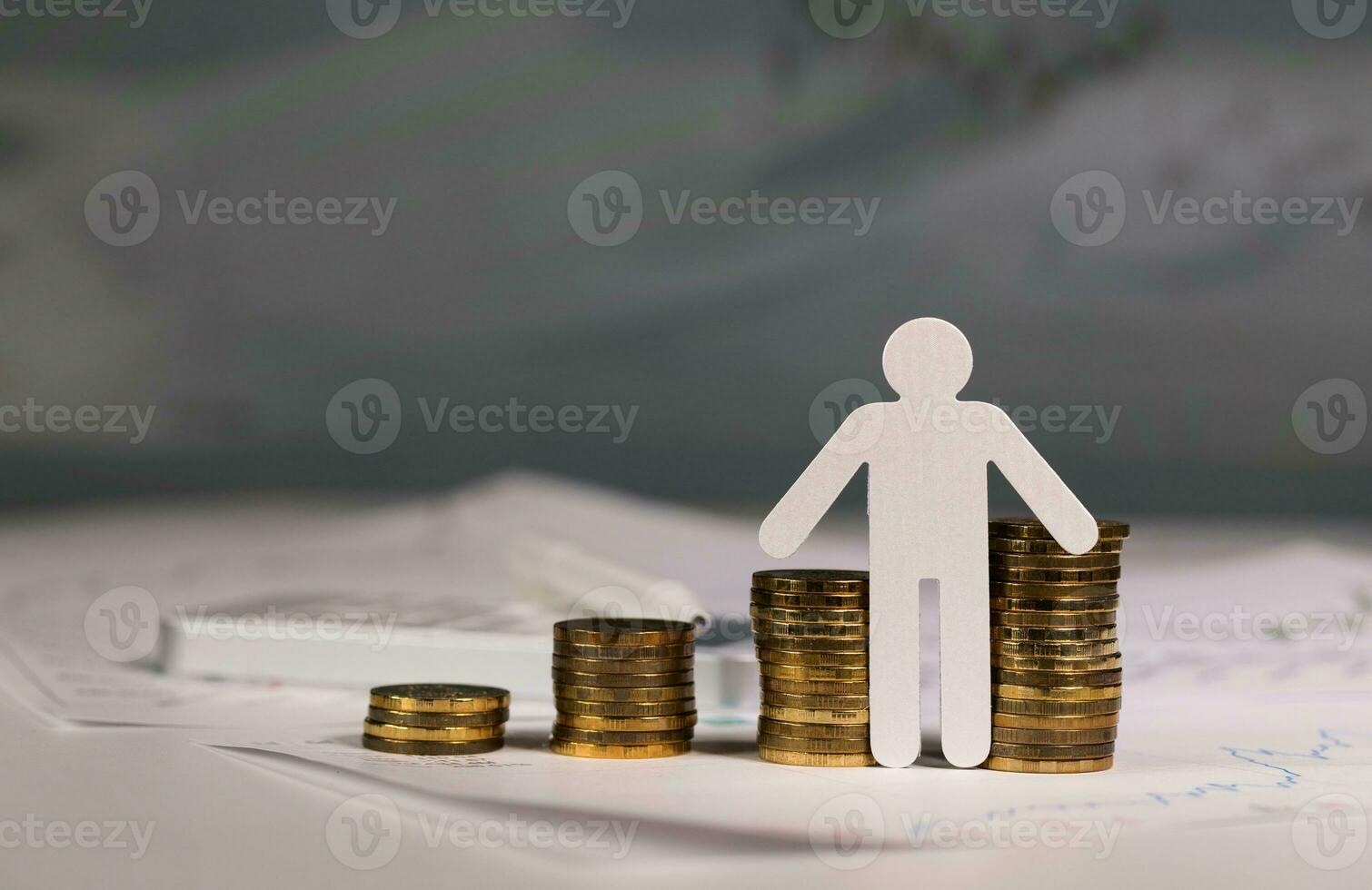 Paper cutout of a person in front of coins stacks. photo