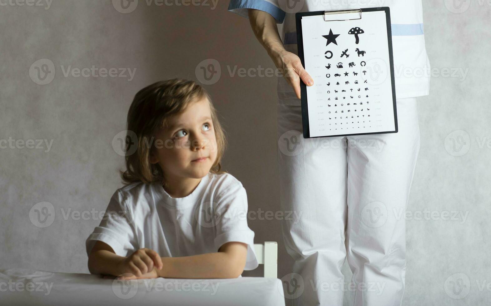 Ophthalmologist checks vision of 5 years old boy photo