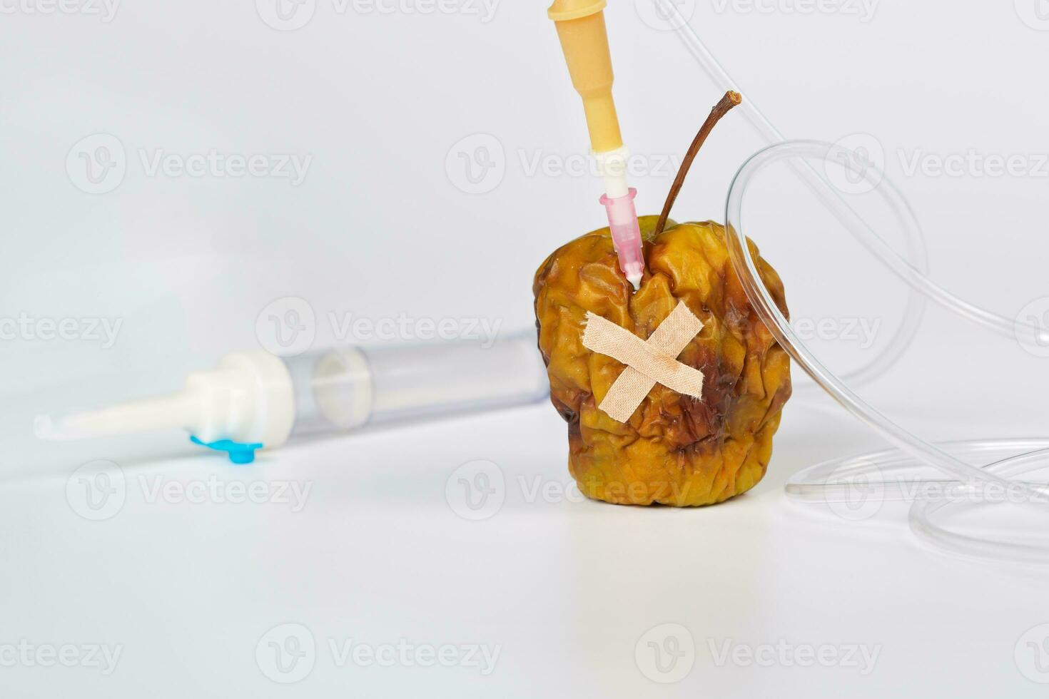 Shrivelled apple with blood transfusion set. photo