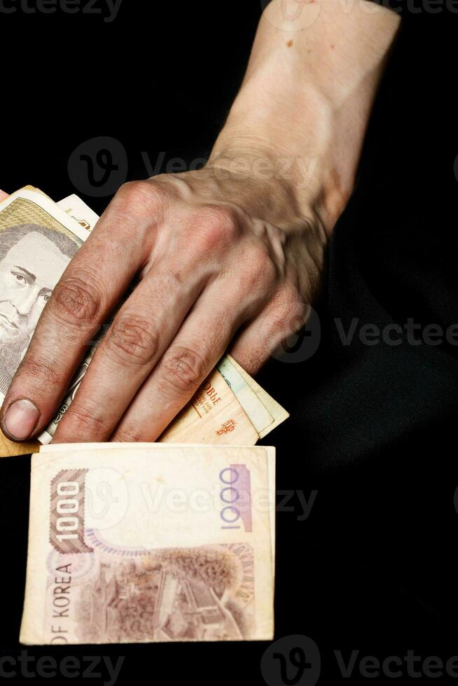 Palm of a peasant woman with old banknotes on a black fabric. Closeup photo