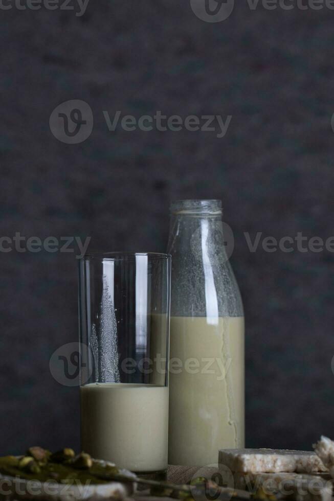 Homemade pistachio nut milk in a glass bottle. photo