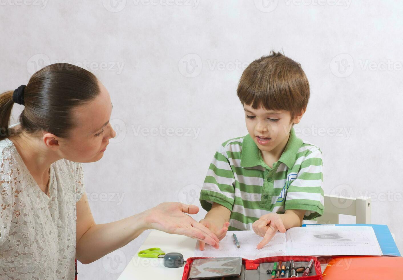 The mother checks the homework of her son photo