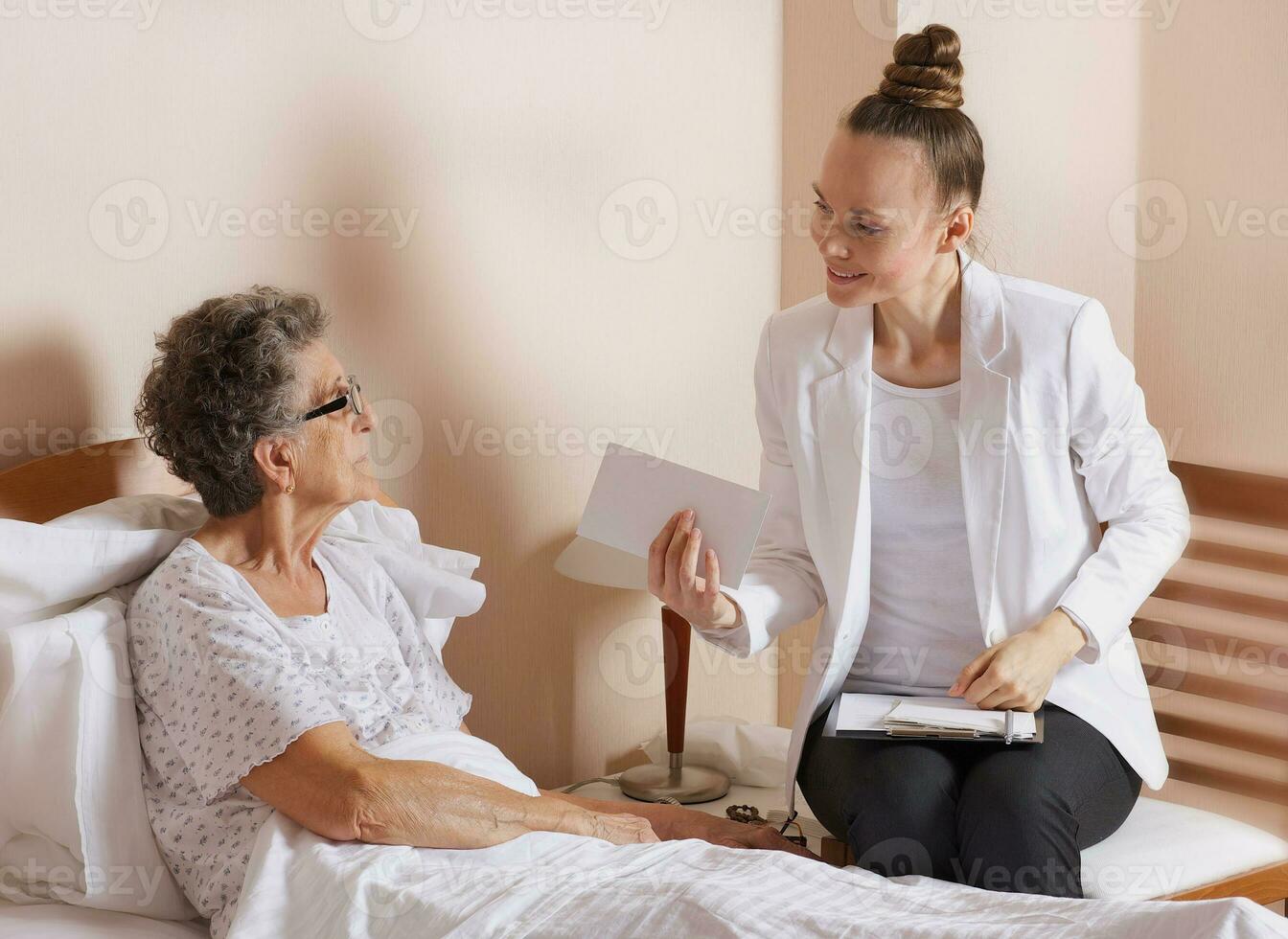 Visit of senior social work assistant to an old woman photo