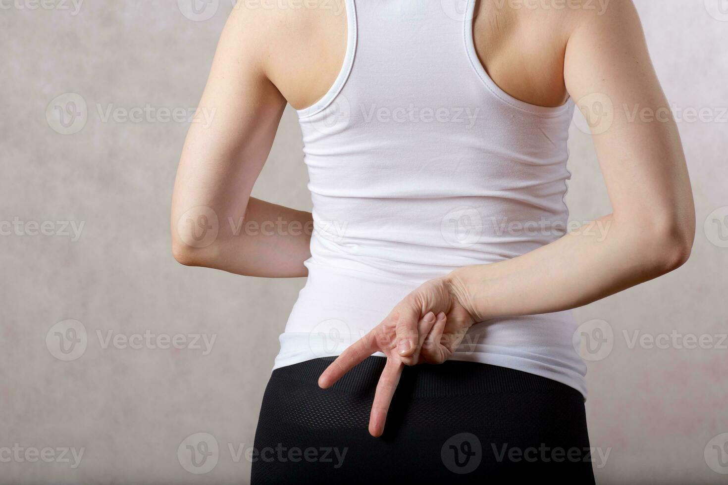 Young lady  hides two fingers behind her back Closeup photo