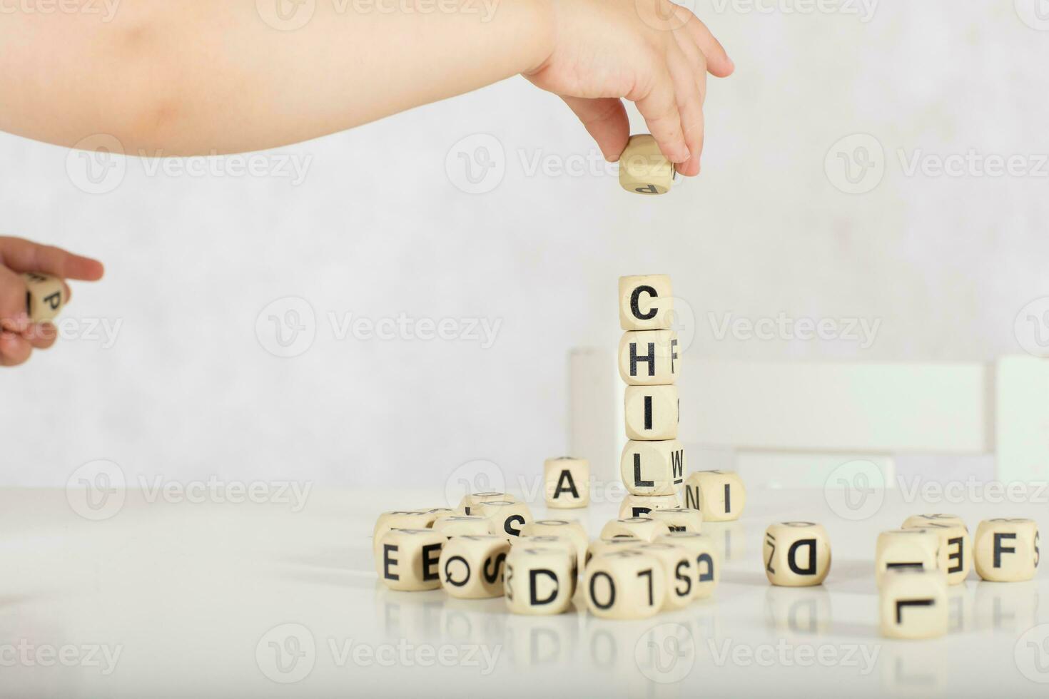 Small girl composes words from letters. Closeup photo