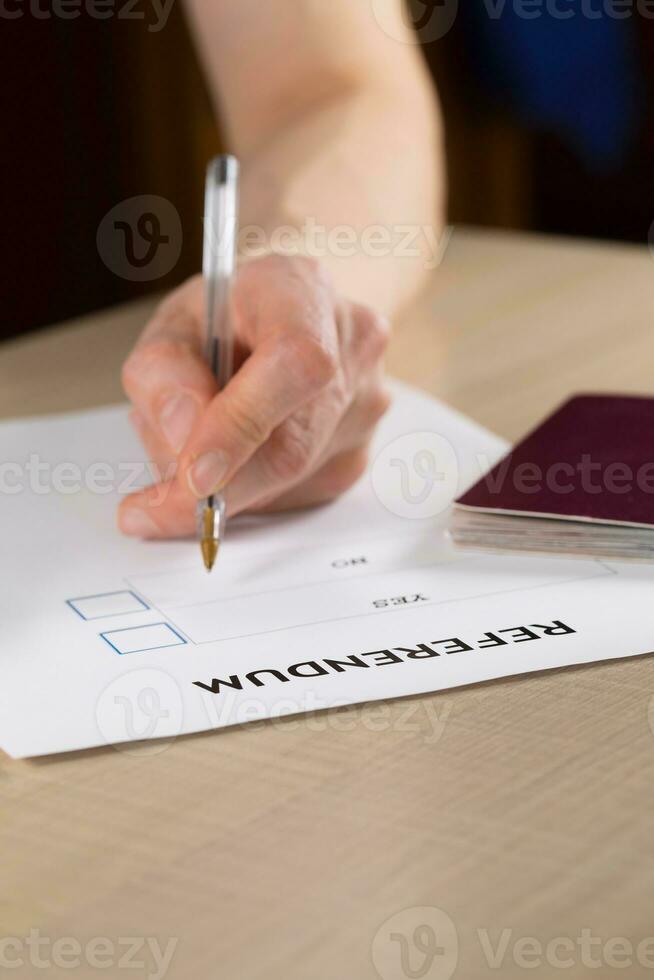 Referendum ballot paper, black pen, and passport on the table. photo