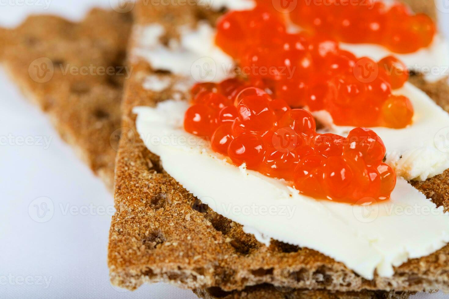 Cereal crispbread crackers with butter and red caviar. photo