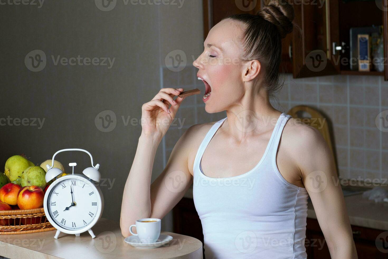 Young caucasian lady is drinking espresso at bar table in the kitchen photo