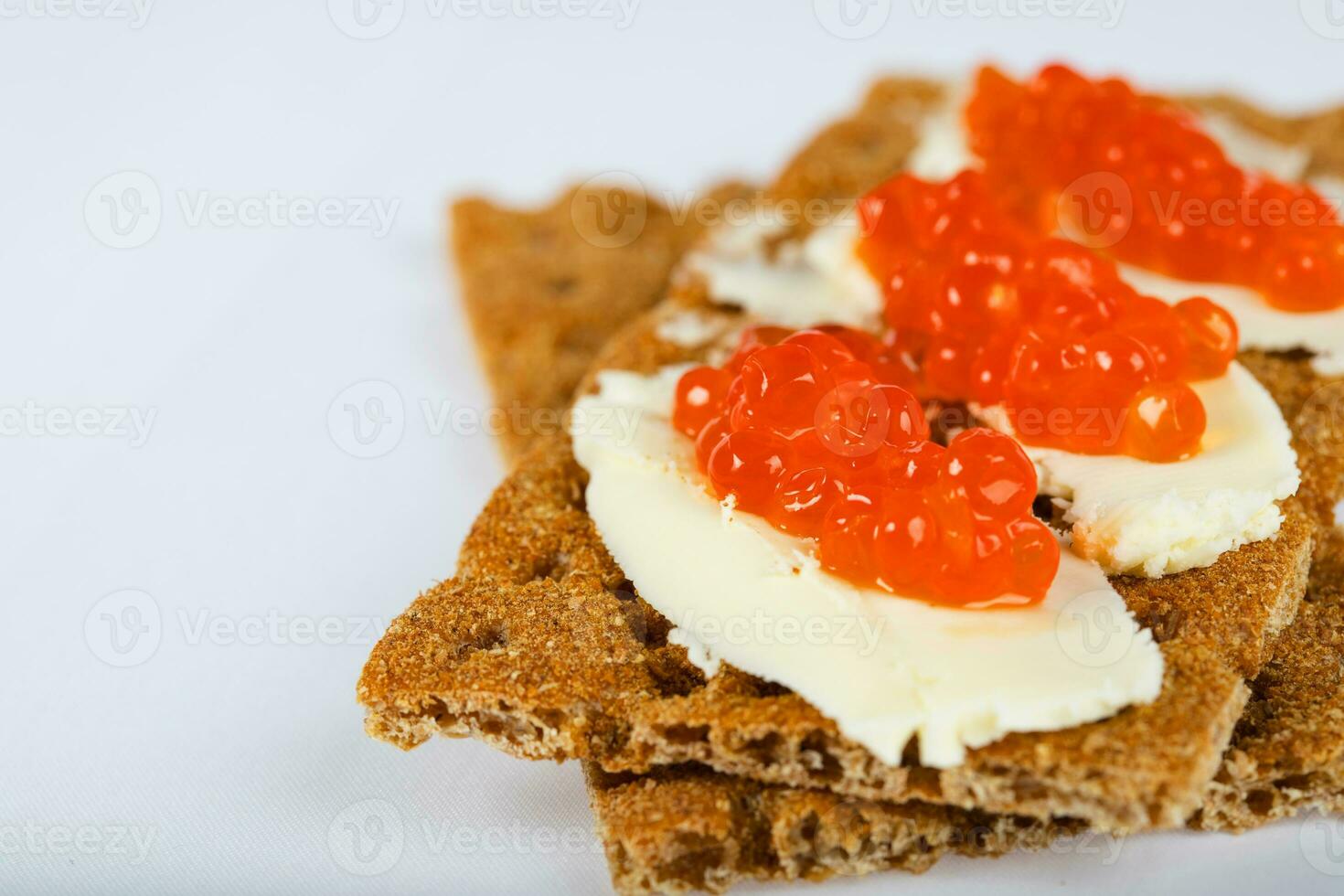 Cereal crispbread crackers with butter and red caviar. photo