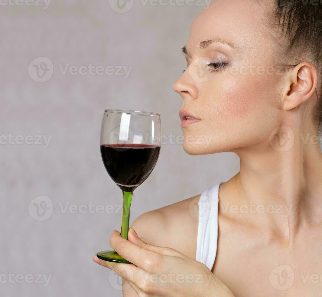 Young lady keeps a glass of red wine. photo