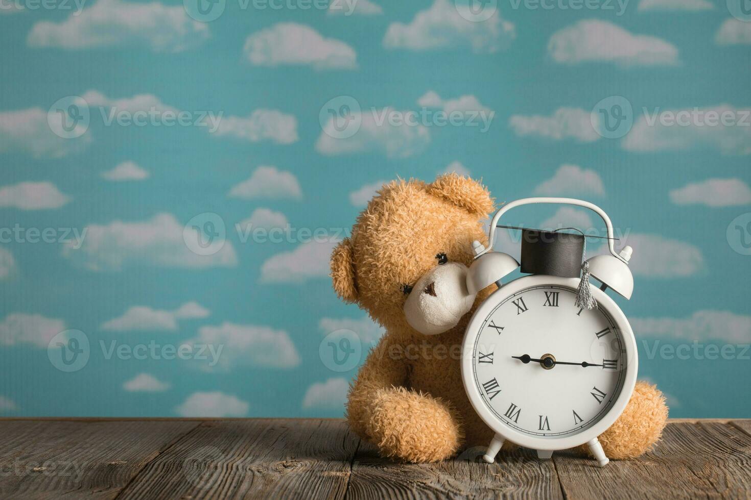 Brown plush teddy bear with academic cap on the top. photo