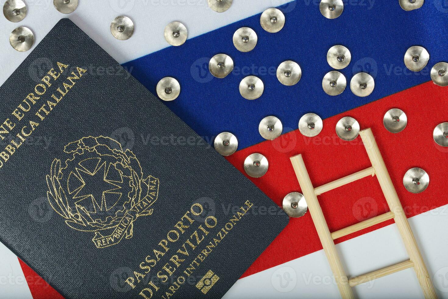 Pins,service pass of an European official written in Italian and mini wooden made ladder on a Russian flag. Background photo