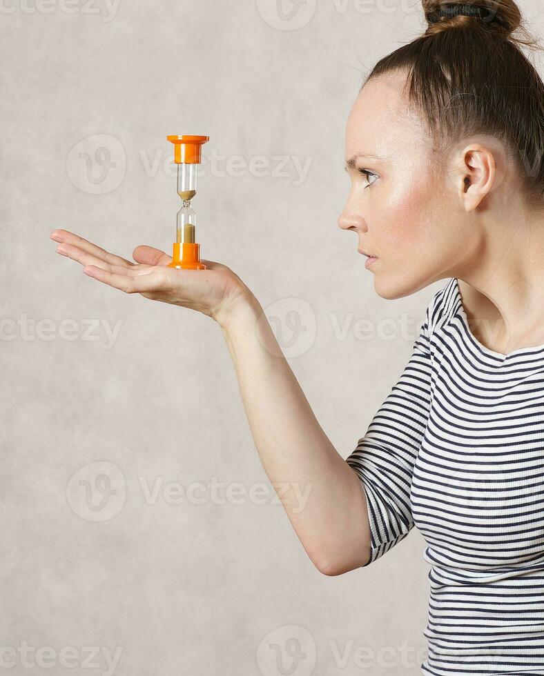 A  young woman and a sand watch photo