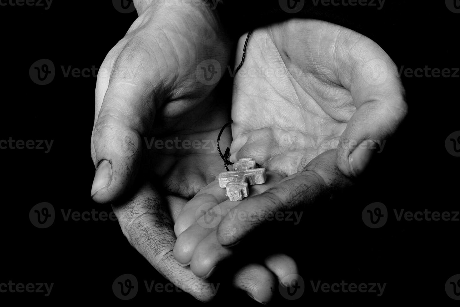 Wooden handmade cross in the palm of a peasant woman. photo