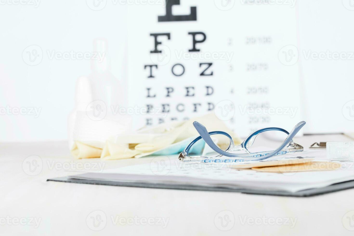 Eyeglasses for children on a eye chart close to eye pads. photo