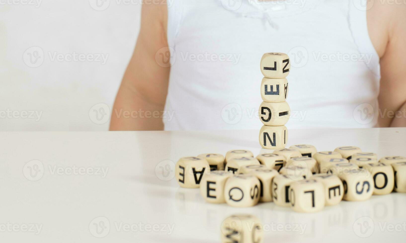 Small girl composes words from letters. Closeup photo