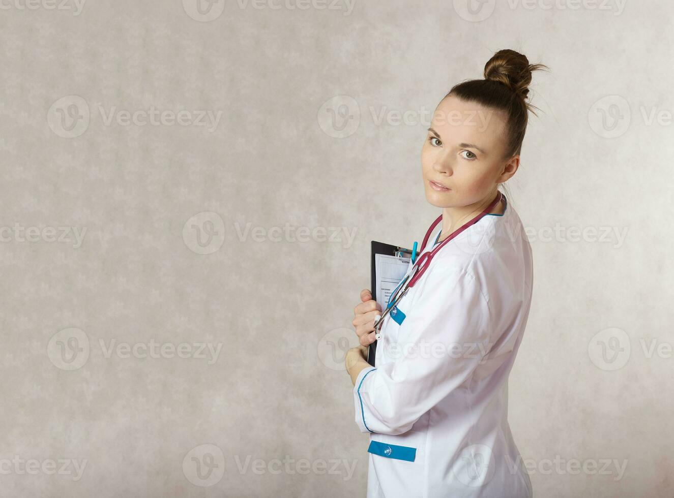 Young female doctor dressed in a white medical uniform photo