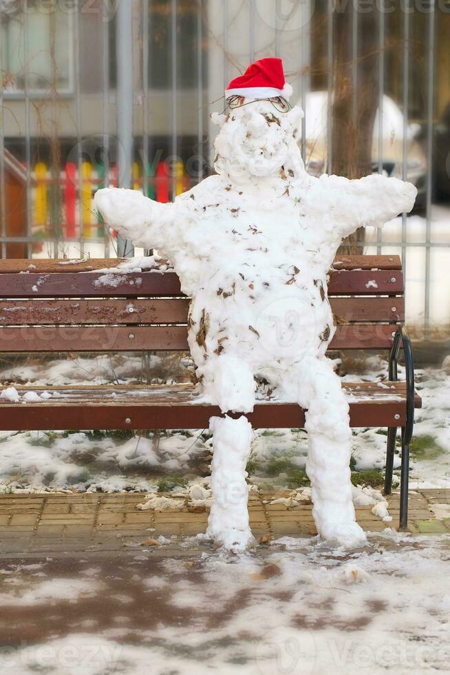 Handmade snowman with red hat made from natural snow photo