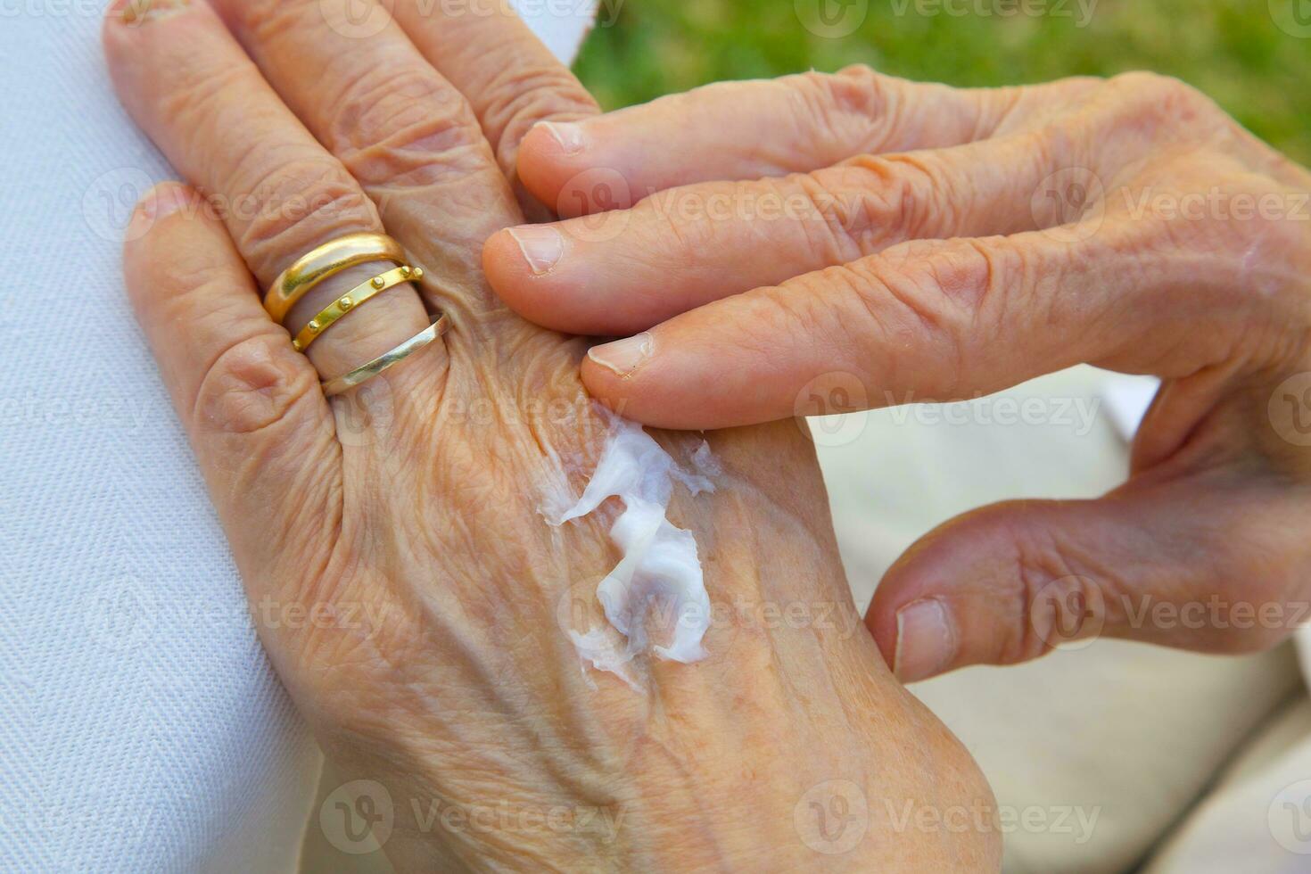 The hand cream on the hands of an old woman photo