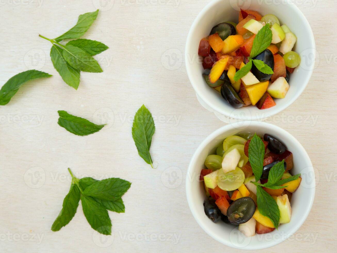 Fruit salad in white dishes photo